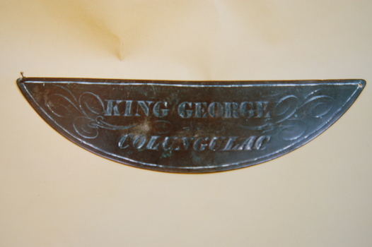 Metal, engraved, crescent shaped breast plate inscribed "KING GEORGE COLUNGULAC"