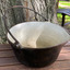 Cast iron outer with white enamel inside with a pouring lip.  Made by T & C Clarke & Co. 14 Quart.