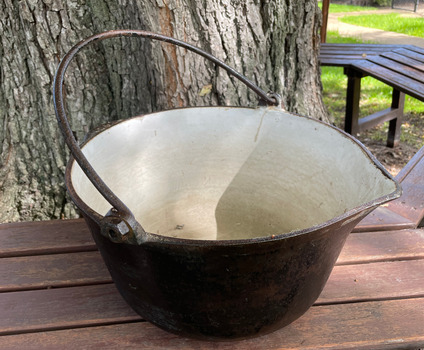 Cast iron outer with white enamel inside with a pouring lip.  Made by T & C Clarke & Co. 14 Quart.
