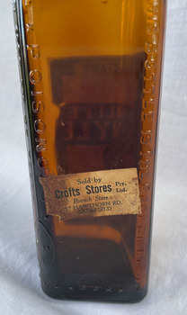 Side view of Pearlite Phenyle Bottle with Crofts Store label.