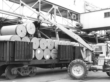 Photograph, Cylindrical containers being loaded from a truck, n.d
