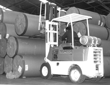 Photograph - Photograph - Cylindrical containers being loaded with a forklift, n.d