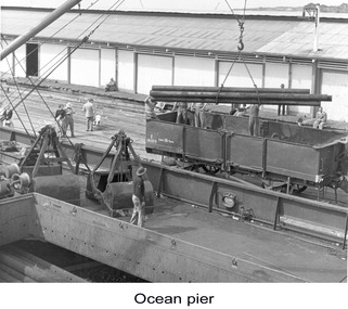 Photograph - Photograph - Metal pipes lifted from train with crane, n.d