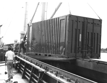 Photograph - Photograph - crane loading container onto hold of a ship, 1980s