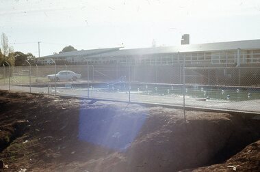 Photograph - Digital Image, Watsonia High School Pool, Construction 1976. Pool behind fence with classrooms in background, 12/12/1976