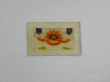 Postcard with white border and hand-sewn rising sun emblem, Australian and UK flags and leaf motif.