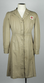 Cream coloured cotton, long sleeve, button-up nurses uniform, with small Red Cross white patch on left side. 