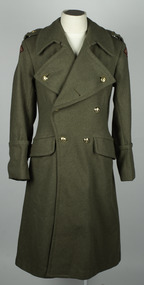 Double breasted Army Khaki coat with brass buttons on manequin with white background.