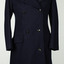 Double breasted navy blue coat with black buttons on a mannequin with white background.