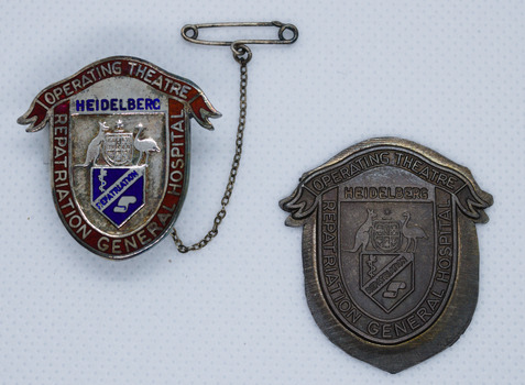 Silver enamel sheid shapped badge with red ribbon top and Australian Coat of Arms. Brass pressing proof of same badge. On white background