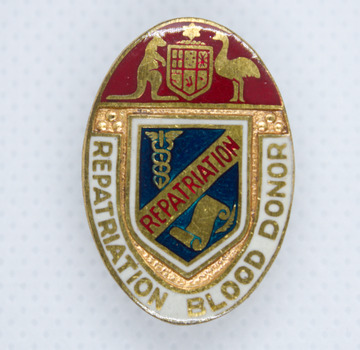 Oval shaped badge with Australian coat of arms on top, blue shield centre, and with white edge with gold writing.