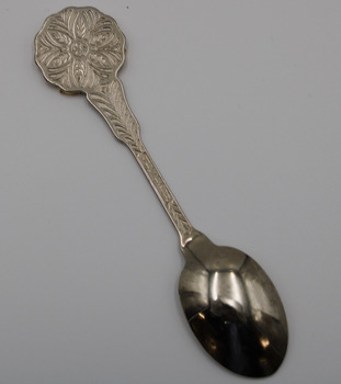 Back view of a teaspoon with round head and stem with embossed pattern