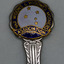 Detail of circular head of silver spoon, white enamel centre with gold Southern Cross stars and blue edge with gold writing