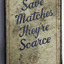 White matchbox with blue writing and red border.