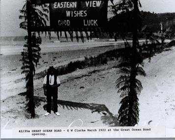 G.W. Clarke standing beneath banner for opening of Great Ocean Road in 1922 at Eastern View