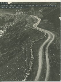 narrow section of Great Ocean road near Sheoak River showing stone barrier on edge