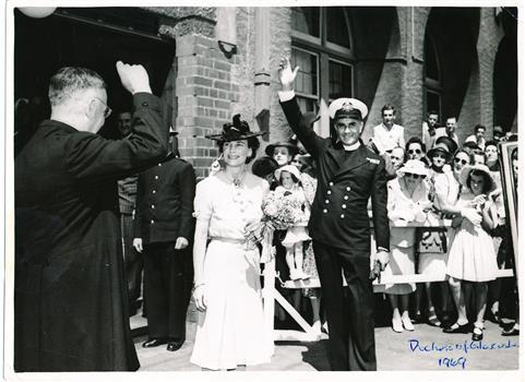 H.R.H. Duchess Alice of Gloucester standing next to Padre Frank Oliver saluting the crowd during a Royal visit to Mission to Seamen