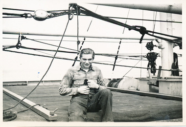 Allan Charles Quinn holding a small monkey on board a ship