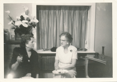 Two senior women pitted in a lounge and talking to each other