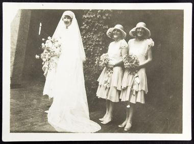 Dora Walker, bride with two bridesmaids in the cloister of the mission