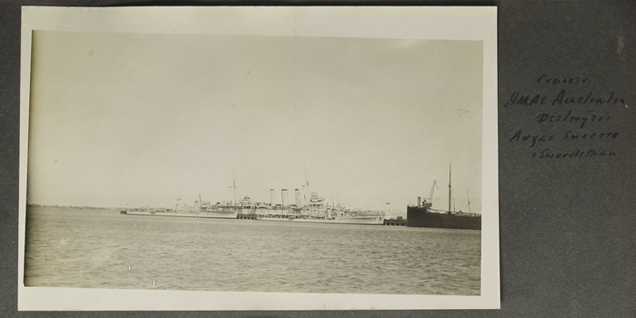Military ships berthed in port.