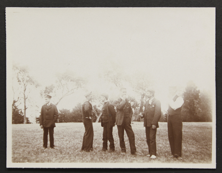 Group of six seamen standing in a park, three of them are smoking.