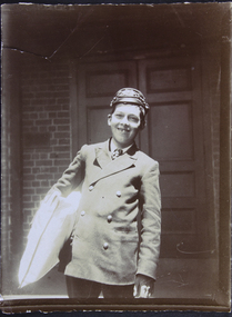 Photograph, Young courier carrying parcel in front of the Siddeley Street Mission, between 1907-1917