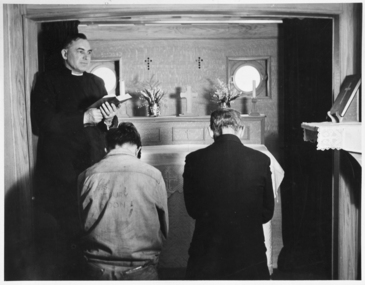 Photograph - Mounted photograph, Black and white, Reverend Fred Laight conducting a service in the floating church the "John Ashley"