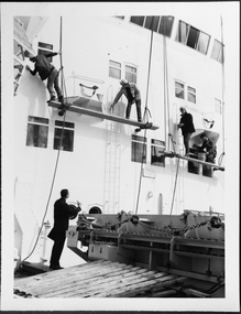 photograph - Photograph, Black and white, Chaplain visiting men painting the hull of a ship