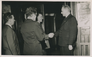 Black and white photograph of Pader Oliver sharing hands with seamenre