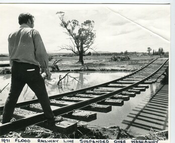 Photograph - 1971 flood, railway line suspended over washaway, 1971