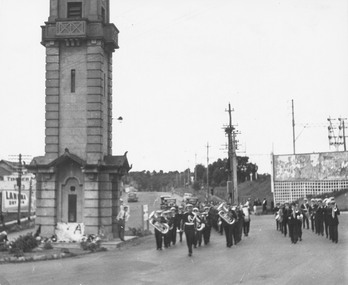 Photograph, Anzac Day, band marching past Ringwood clock tower. c1940's