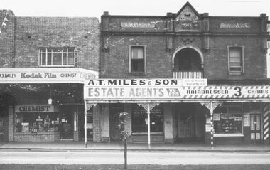 Photograph, Shops fronting Whitehorse Road, Ringwood, opposite Railway Station - 1966.  Bailey, Chemist, A.T. Miles & Son, Estate Agents, Coffee Palace, and Mens Hairdresser (Roy Hill)