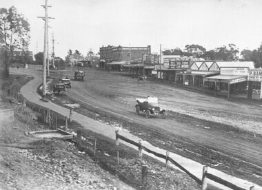 Photograph, Maroondah Highway Central, Ringwood. Main street, Ringwood c1924. showing cars and horse-drawn carriages in front of shops - undated but possibly c1924