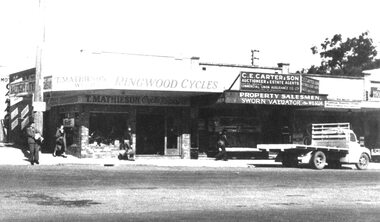 Photograph, Main Street Ringwood, T. Mathieson Cycles on corner of station entrance, C.E. Carter to right. c1950