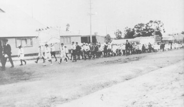 Photograph, Ringwood School banner carried by children marching in procession past coolstore on Maroondah Highway, Ringwood, near the Wantirna Road corner. c.1920