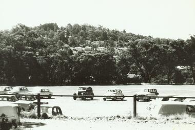 Photograph, Ringwood Oval (now Eastland) looking at Loughnan's Hill with cars in car park  (mid-late 1960's)