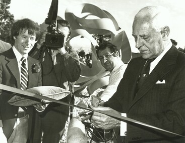 Photograph, Official opening of the Karralyka Centre, Mines Road, Ringwood on 19/4/1980 - Victorian Governor Sir Henry Winneke cutting the ribbon, officials looking on, new sculpture in background, 19-Apr-80