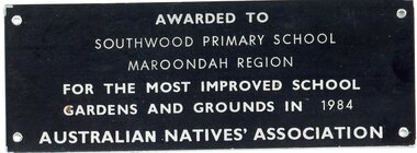 Plaque, Small black metal plaque with white printing awarded to Southwood Primary School for the most improved school gardens and grounds in 1984 by Australian Natives Assoc, 1984