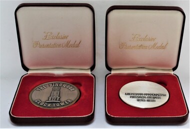 Memorabilia - Presentation Medal in Case (x2), P J A, Circular metal medal with gold coloured rim, in brown leather case with red velvet cushion and white lining in lid, commemorating the Ringwood Clocktower Diamond Jubilee 1928-1988, 1988