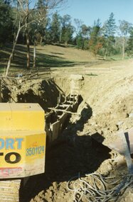 Photograph, The Kato working on the pumping plant at the end of the sewer trench near Glenvale Road, North Ringwood, on 10 June 1978. Loughnan's Lake site shown as a grassy hollow in the background