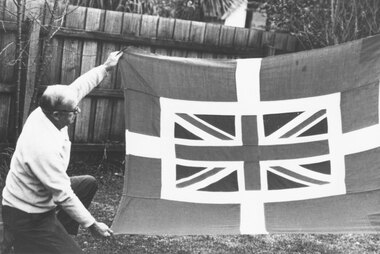 Photograph, Paddy Miles displaying 'Captain Miles House Flag'- c 1970's