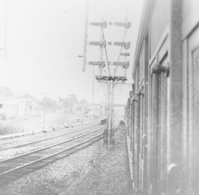 Photograph, View from train at the Warrandyte Road Railway Bridge facing west, with Blood Bros. store on the left, and footbridge overhead in the distance