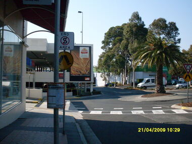 Photograph, Looking along access road across carpark towards former Harris Scarfe store, looking east, on 21 April 2009. Showing part of Eastland multi-story car park