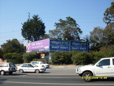 Photograph, Looking south south-east at Maroondah Highway and Warrandyte Road intersection, on 21 April 2009, showing advertising signs