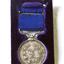 Silver medal hangs from a blue ribbon