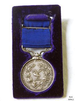 Silver medal hangs from a blue ribbon