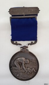 Silver bar with inscription, attached to blue ribbon with silver medal hanging rom it