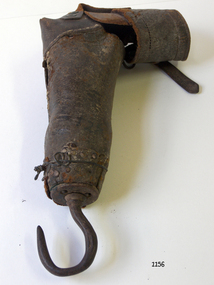 Brown leather arm is bent at the elbow and has a hook where a hand would normally be