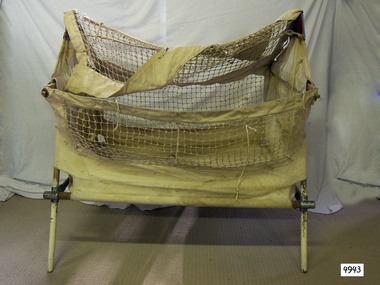 Fabric and wood cot made for folding and travel.